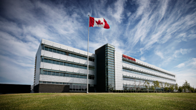 Wide view of a Honda building with a Canadian flag waving on a flagpole in the foreground.