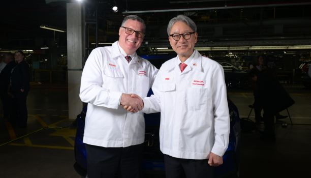 Deux ingénieurs masculins de Honda portant des sarraus et se serrant la main.