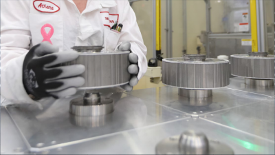 A close-up of a Honda employee in a manufacturing facility handles a lithium battery. 