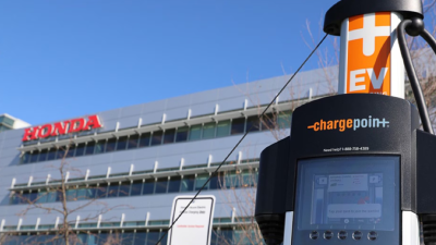 The exterior of the Honda headquarters building is shown with an electric charging station in the foreground. 