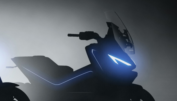 A blue motorcycle in a neutral environment is in a medium-shot with an illumination on the tank. 
