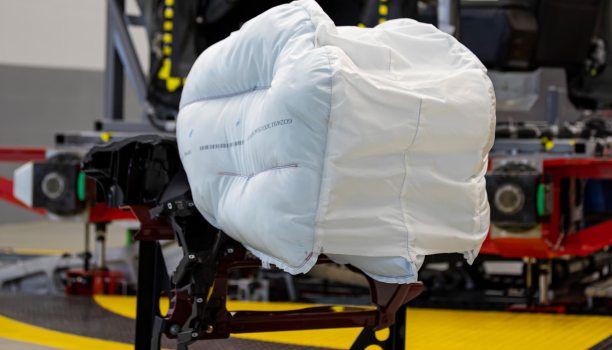 A wide-shot of an airbag being tested in a manufacturing facility. 
