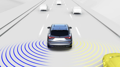A graphic illustration of a vehicle is depicted on a highway with sensors emitting from the rear.